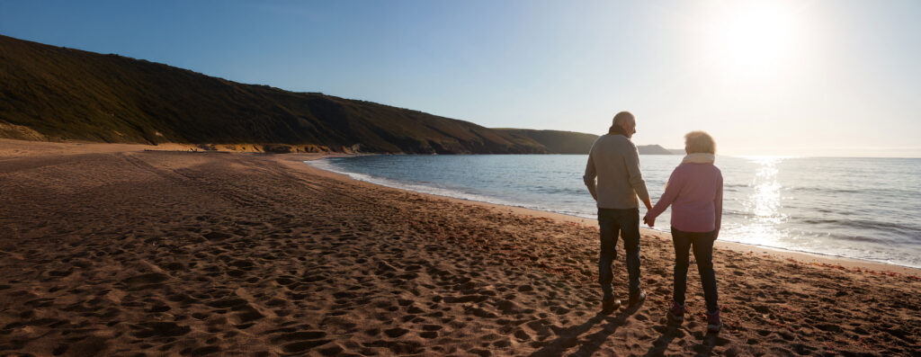 Retired couple on an beach at low sun 